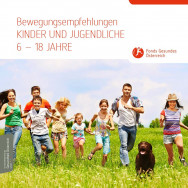 Kinder und Jugendliche laufen mit einem Hund über die Wiese