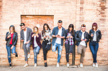 Foto: Gruppe junger Menschen. Alle schauen auf ihr Handy.