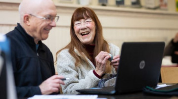 Zwei ältere Menschen vor einem Laptop