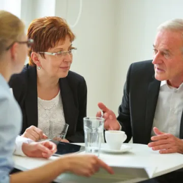 Foto: Drei Personen sprechen miteinander