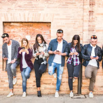 Foto: Gruppe junger Menschen. Alle schauen auf ihr Handy.