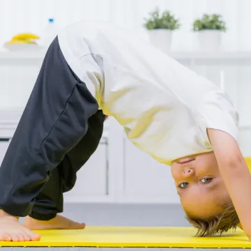 Kleiner Bub turnt am Boden