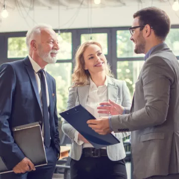 © Bojan / AdobeStock Älterer Mann mit zwei jüngeren Mitarbeitern im Büro