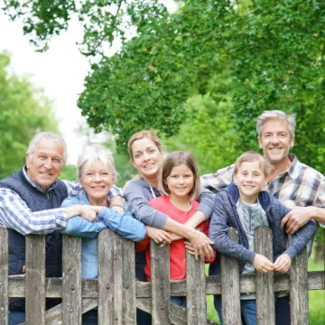 Fröhliche Personen an einem Gartenzaun