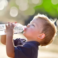 Ein Kleinkind trinkt Wasser aus einer Flasche