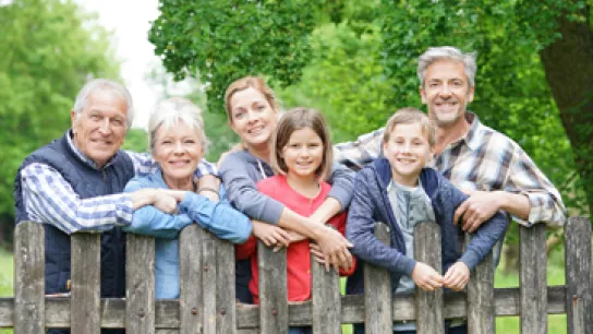 Foto: Eine freundliche Personengruppe am Gartenzaun