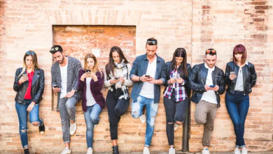 Foto: Gruppe junger Menschen. Alle schauen auf ihr Handy.