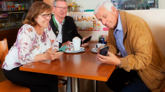 Ein Senior erklärt die Funktionsweise eines Smartphones