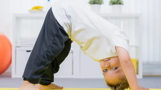 Kleiner Bub turnt am Boden