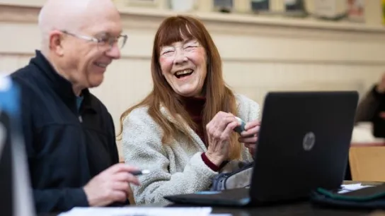 Zwei ältere Menschen vor einem Laptop